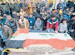  ?? ALI NAJAFI/GETTY-AFP ?? Mourners pray Thursday in Najaf, Iraq, over the coffin of a person killed in twin suicide bombings in Baghdad that left at least 32 dead and 110 wounded.