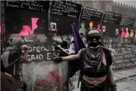  ?? City. Photograph: Mahé Elipe ?? Protestors painted the names of female murder victims onto fences erected in front of the national palace in Mexico