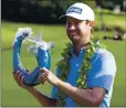  ?? MATTHEW THAYER — THE ASSOCIATED PRESS ?? Harris English holds the champions trophy after winning the Tournament of Champions in a playoff Sunday at the Kapalua Plantation Course.