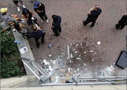  ?? The Associated Press ?? DAMAGE: Police stand by a damaged storefront stemming from overnight protests Thurseday following Tuesday's police shooting of Keith Lamont Scott in Charlotte, N.C. Charlotte's police chief said Thursday he plans to show video of an officer shooting...