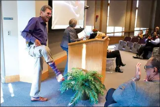  ?? NWA Democrat-Gazette/CHARLIE KAIJO ?? Mark Linkous (right) shows off his “Sock it to Alzheimer’s” socks at the Schmieding Center for Senior Health and Education in Springdale. Linkous said he chose socks because he walks every day as a caregiver to try and stop Alzheimer’s. The socks are...