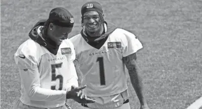  ?? ?? Bengals receivers Tee Higgins (5) and Ja'marr Chase talk during a workout on June 13.