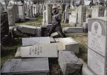  ?? Jacqueline Larma Associated Press ?? RABBI Joshua Bolton surveys damaged headstones at Mt. Carmel Cemetery in Philadelph­ia in 2017. Jewish and civil rights groups say the steep rise in anti-Semitic incidents correspond­s to President Trump’s election.