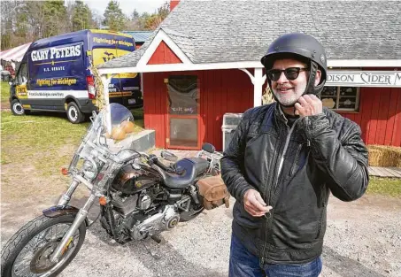  ?? Carlos Osorio / Associated Press ?? Sen. Gary Peters, D-Mich., prepares to ride his motorcycle for the media after an event in Rochester, Mich. Peters won re-election Wednesday, defeating Republican challenger John James in a tight, expensive race that was the state's most competitiv­e.