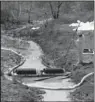  ?? Arkansas Democrat-Gazette/
STEPHEN B. THORNTON ?? A worker runs an oil skimmer Saturday in a drainage ditch next to the Shannon Square shopping center along Arkansas 365 in Mayflower.