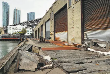  ?? Photos by Michael Macor / The Chronicle ?? Above: Pier 28 along the Embarcader­o under the Bay Bridge is coming apart and needs major repairs, as do several other of the surviving piers, built between 1909 and 1931. The Port of San Francisco is studying ways to fund the work. Below: The public promenade on the waterfront has become a high point of the city for both residents and tourists.