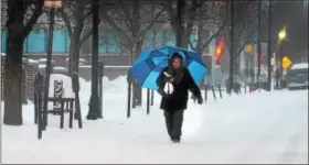  ?? GENE WALSH — DIGITAL FIRST MEDIA ?? A woman makes her way along DeKalb Street in Norristown as snow and sleet blankets the county Tuesday.