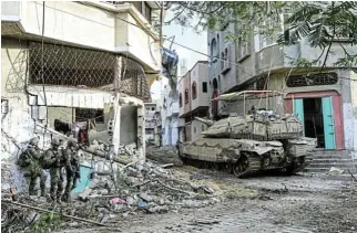  ?? /Reuters ?? Humanitari­an crisis: Israeli soldiers stand nearby a tank. Militant group Islamic Jihad, which is allied to Gaza’s Hamas rulers, says that its fighters are battling Israeli forces in Khan Younis, in the southern Gaza Strip.