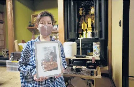  ?? HIRO KOMAE/AP ?? Kaori Takada poses with her brother’s photo in front of an altar last week at her home in Matsubara, south of Osaka in western Japan.