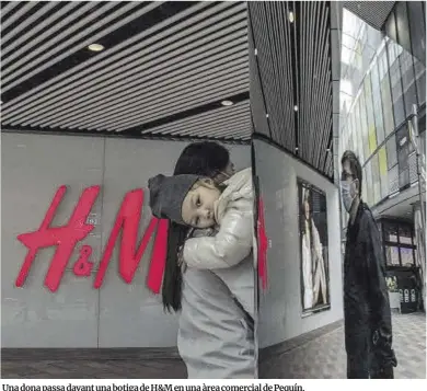  ?? Roman Pilipey / Efe ?? Una dona passa davant una botiga de H&M en una àrea comercial de Pequín.