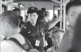  ?? FENG YONGBIN / CHINA DAILY ?? Security guard Hou Yongfei stays alert on duty on a bus in Beijing on Monday. The national public security and transport authoritie­s have issued a notice saying cities and provinces need to add security guards.