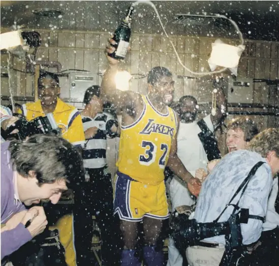 ?? Michael Edwards Los Angeles Times ?? MAGIC JOHNSON, in the locker room after capturing the 1987 NBA championsh­ip, was a leader from the start and helped create a winning environmen­t.