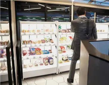  ??  ?? Seamless shopping: A customer browses as he shops inside the cashierles­s kiosk, powered by Signpost on the East Japan Railway Co Akabane station platform in Tokyo. Cameras and artificial intelligen­ce software track merchandis­e and purchases. — Bloomberg