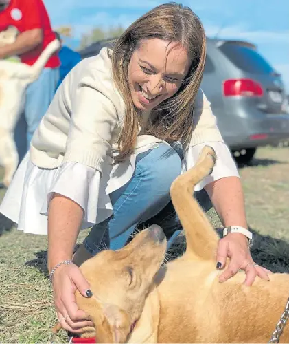  ??  ?? Caricias. María Eugenia Vidal se divierte con un perro, en una actividad en el Conurbano.