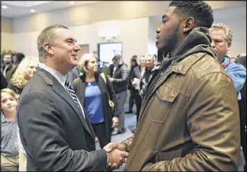  ?? DAVID BARNES / DBARNES@AJC.COM ?? New Georgia State coach Shawn Elliott meets quarterbac­k Emiere Scaife before his introducto­ry news conference last month.