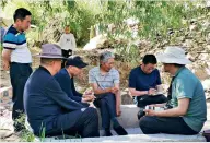  ??  ?? Yang Guifang (center) talks with visitors.