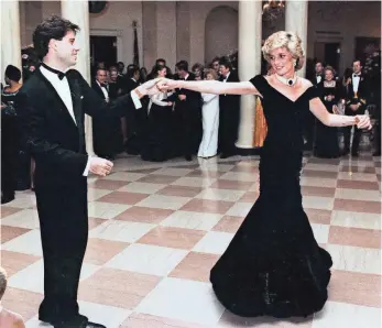  ?? RONALD REAGAN PRESIDENTI­AL LIBRARY VIA AP ?? Princess Diana dances with John Travolta at a White House dinner in November 1985. The dark blue Victor Edelstein dress she wore sold at auction for $222,500 in 1997.