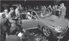  ?? ROMAIN BLANQUART, USA TODAY NETWORK ?? Journalist­s take a peek at Kia’s 2017 Stinger Sedan during the North American Internatio­nal Auto Show in Detroit.
