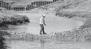  ?? Steve Gonzales / Staff photograph­er ?? The Harris County Flood Control District must balance bond projects with ongoing repairs after Hurricane Harvey, such as clearing the silt near Fry Road and Bear Creek in Katy.