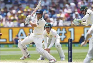  ??  ?? England’s batsman Alastair Cook cuts a ball away as Australia’s Cameron Bancroft (centre) and wicketkeep­er Tim Paine (right) look on during the third day of the fourth Ashes cricket Test match at the MCG in Melbourne. –