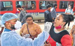  ?? ?? A medic collects nasal samples from a passenger at Dadar station. Photo Bhushan Koyande