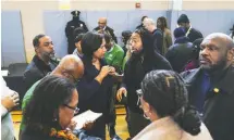  ?? Carolyn Van HOUTEN/THE Washington POST ?? Mayor Muriel E. Bowser, center, talks to neighborho­od commission­ers and community members about crime on Jan. 21.