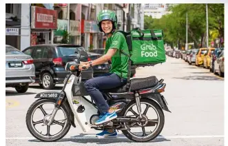  ??  ?? Food delivery riders have become ubiquitous in urban centres as demand for food delivery services have increased over the years. — Grabfood