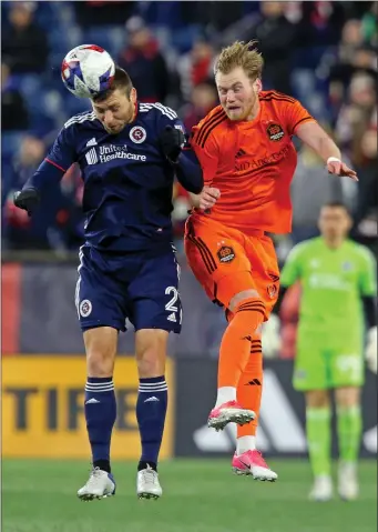  ?? STUART CAHILL — BOSTON HERALD ?? New England Revolution defender Dave Romney, left, heads the ball in front of Houston Dynamo forward Þorleifur Úlfarsson during a March 4 game in Foxboro.