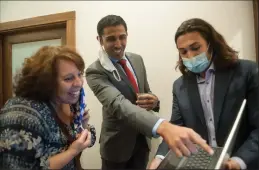  ??  ?? Mikey Hothi, center, reacts to the first round of election results as he checks them with June Atwood Aaker, left, and Chris Smith on election night in Lodi. Hothi appeared headed to victory in the Lodi City Council race to represent District 5.