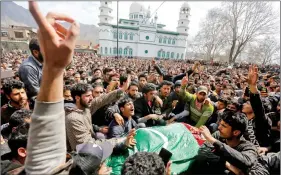  ?? REUTERS ?? People shout slogans as they gather around the body of Shabir Ahmad, a suspected terrorist who was killed in a gun battle with the security forces, during his funeral at Aghanzipor­a village, in South Kashmir’s Pulwama district on Friday.