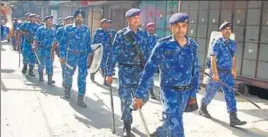  ?? HT PHOTOS ?? A poster declaring Yashwant Bobby a martyr; (right) a flag march by Rapid Action Force personnel, in Phagwara on Saturday.