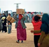  ??  ?? Nel campo Una donna trasporta una scatola piena di cibo fornito da una agenzia delle Nazioni Unite in un campo per sfollati a Deir ez-zor, in Siria (Afp)