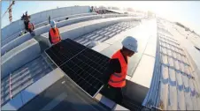  ?? SUN LIJUN / FOR CHINA DAILY ?? Workers install photovolta­ic power generation plates on the roof of Fengtai Railway Station in Beijing.