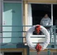  ?? MARK HUMPHREY — THE ASSOCIATED PRESS FILE ?? In file photo, a woman looks out of a window while visiting the National Civil Rights Museum located at the Lorraine Motel in Memphis, Tenn., on the nationwide holiday honoring Martin Luther King Jr. The wreath marks the location where King was killed...