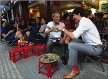  ?? The Canadian Press ?? Canadian Prime Minister Justin Trudeau speaks with Nguyen Cong Hiep as the two stop for a drink at local cafe in Ho Chi Minh, Vietnam, Thursday.