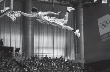  ?? YANG BO / CHINA NEWS SERVICE ?? Seemingly impervious to the forces of gravity, a basketball player performs a majestic dunk at an exhibition game in Nanjing, Jiangsu province, on Saturday.