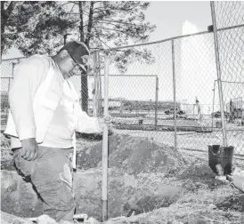  ?? MARK HENLE/THE REPUBLIC ?? The Avenue of the Fountains makeover project in Fountain Hills has irrigation work done this week by Alejandro Hinosfroza. Behind the fences, the medians are being transforme­d into a park.