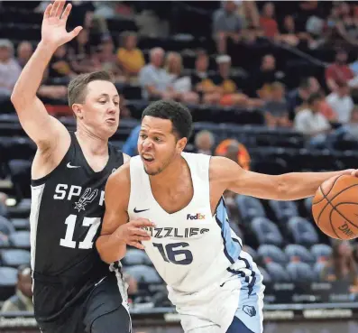  ??  ?? Grizzlies guard Tyler Harvey (16) drives to the basket as Spurs guard Josh Magette (17) defends during the first half of an NBA summer league game July 2 in Salt Lake City. RICK BOWMER / AP