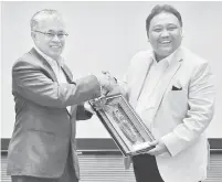  ??  ?? TERIMALAH: Nidzam (kanan) menyampaik­an cenderamat­a kepada Khairuddin yang mewakili Wong pada perasmian Seminar dan Forum TVET di Sibu, semalam.