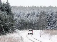  ??  ?? A car makes its way along a snowy road near Leochel-Cushnie