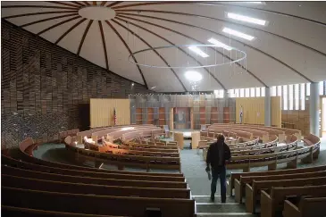  ?? PHOTOS BY ALAN DEP — MARIN INDEPENDEN­T JOURNAL ?? Maintenanc­e supervisor Kirk Kim walks through the sanctuary of Congregati­on Kol Shofar in Tiburon. Passover services will not be held in the sanctuary due to the ongoing shelter-in-place order.