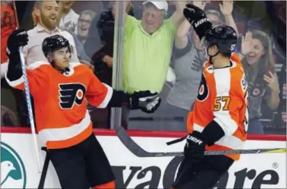  ?? TOM MIHALEK — THE ASSOCIATED PRESS ?? Flyers sophomore forward Travis Konecny, left, and rookie hopeful Travis Sanheim celebrate Konecny’s game-winning goal in overtime Tuesday as the Flyers beat the Rangers, 4-3, in a preseason game at Wells Fargo Center.