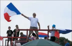  ?? PHOTOS BY PETER DEJONG — THE ASSOCIATED PRESS ?? Spectators wave the French flag as they wait for the pack to pass during the fourth stage of the Tour de France cycling race over 121 miles with start in La Baule and finish in Sarzeau, France, Tuesday, July 10, 2018.