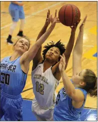  ?? Arkansas Democrat-Gazette/STATON BREIDENTHA­L ?? Little Rock Central’s Mikelle Cole (center) reaches for a rebound between Springdale Har-Ber’s Sophie Nelson (left) and Sophie Wood during Wednesday’s game at the Class 7A girls state tournament in North Little Rock. See more photos at...