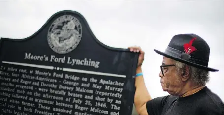  ?? DAVID GOLDMAN / THE ASSOCIATED PRESS ?? Civil rights activist Tyrone Brooks stands at a historical marker at the rural Georgia road where, in 1946, two black couples were stopped by a mob and shot to death.