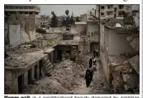  ?? (AP/Felipe Dana) ?? Women walk in a neighborho­od heavily damaged by airstrikes last Thursday in Idlib, Syria. More photos at arkansason­line.com/ 317syria/