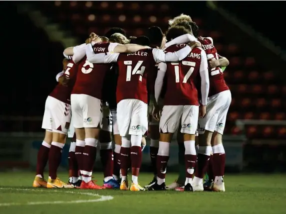  ?? (Getty) ?? Northampto­n Town players huddle ahead of kick-off against Rochdale