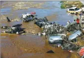  ?? WANG QIANG / FOR CHINA DAILY ?? Rescuers deal with wrecked vehicles after flooding in Yongji county, Jilin province, on Saturday.