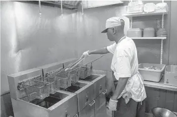  ?? MICHAEL LAUGHLIN/SOUTH FLORIDA SUN SENTINEL PHOTOS ?? Chef Roy Glover cooks chicken wings at Plantation’s Wicked Wings on Thursday. The cost of chicken wings has tripled amid rising food costs in a year, but the restaurant remains open.