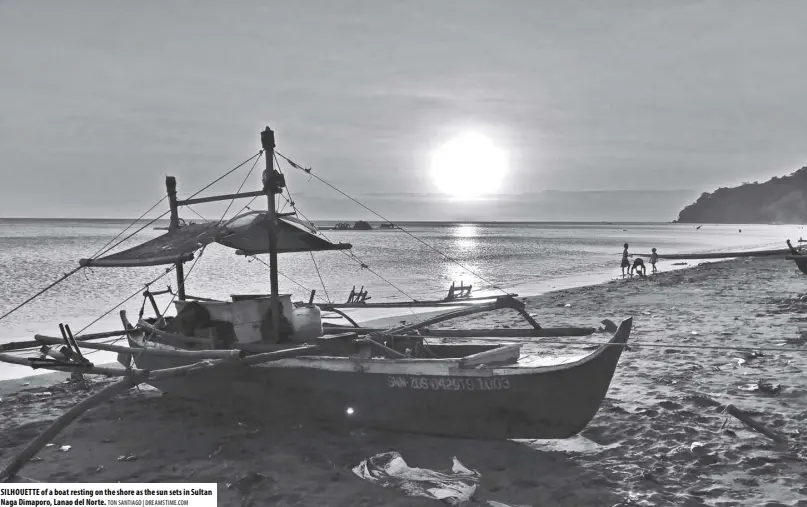  ?? TON SANTIAGO | DREAMSTIME.COM ?? SILHOUETTE of a boat resting on the shore as the sun sets in Sultan Naga Dimaporo, Lanao del Norte.